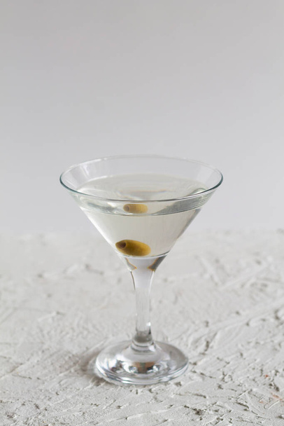 margarita cocktail in the bar. martini glass of cocktail with olives on white background. Glasses for martini on the table. copy space. alcohol drinks. vertical - Foto, Imagen