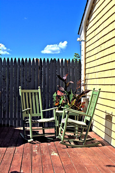 Δύο πράσινες κουνιστές καρέκλες δημιουργούν μια ειρηνική σκηνή - Φωτογραφία, εικόνα