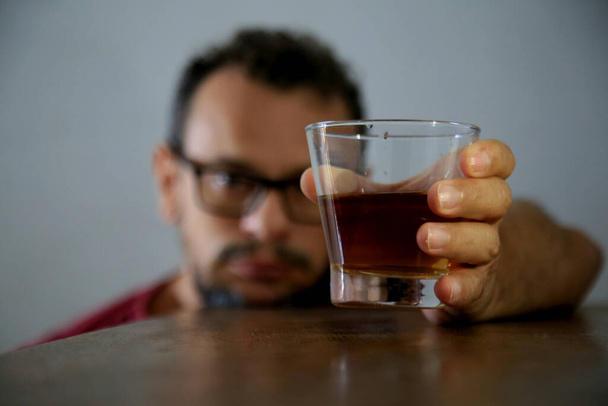salvador, bahia, brésil - 31 décembre 2020 : l'homme alcoolique est vu à côté d'un verre de boisson alcoolisée dans la ville de Salvador. Légende locale * * * * - Photo, image