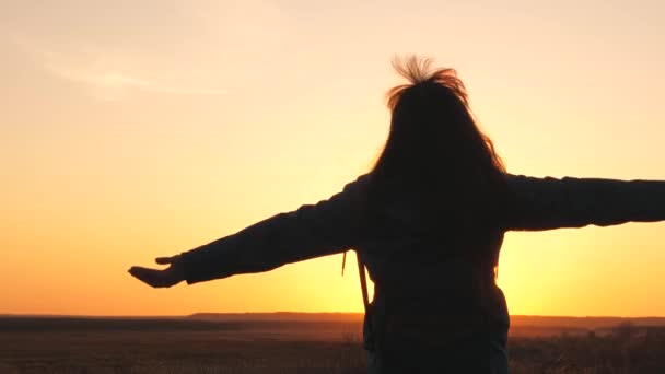 Happy girl traveler with a backpack whirls at sunset with her arms wide open to the sides. A woman on a tourist is resting in a tourist ticket. A hike for people tired of work. A life of exploration - Footage, Video