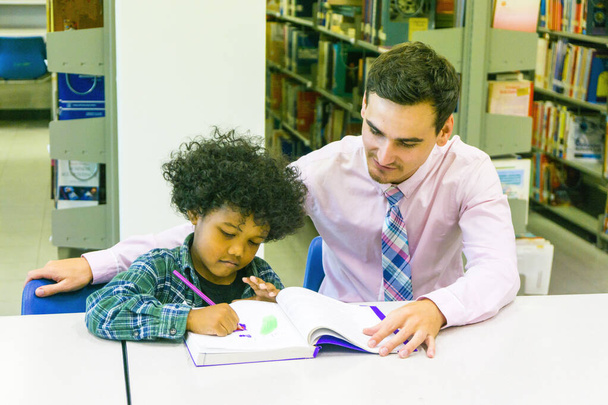 hombre profesor y niño estudiante aprender con libro en librería fondo - Foto, Imagen