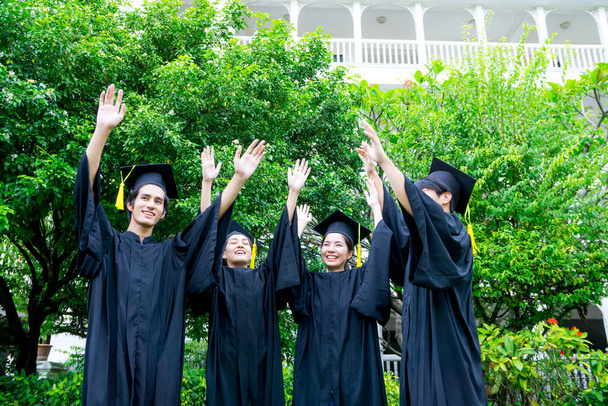 group of Portrait happy students in graduation gowns holding diplomas on university campus - Фото, изображение