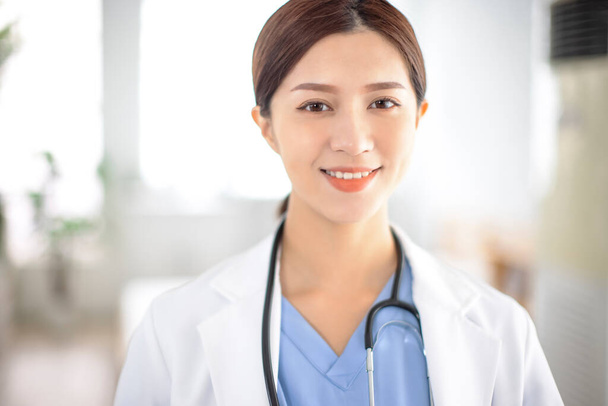 sorridente asiatico sicuro di sé medico femminile in ospedale - Foto, immagini