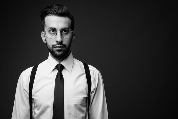 Estudio plano de joven guapo barbudo empresario iraní sobre fondo marrón - Foto, Imagen