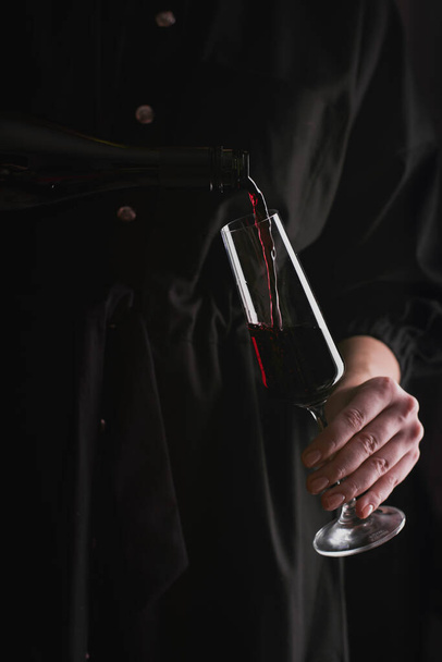 Frau gießt Rotwein in Glas - Foto, Bild