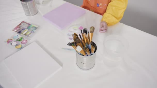 小さな女の子は、 COVID-19中に自宅での距離学習のための彼女のアートプロジェクトに取り組んでペンディアム. - 映像、動画