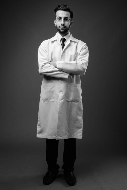 Genç, yakışıklı, sakallı İranlı doktorun çekimleri kahverengi arka planda. - Fotoğraf, Görsel