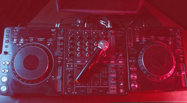Gece kulübü, gece hayatı konsepti. Disko. DJ kumandasındaki mikrofon. Duotone etkisi - Fotoğraf, Görsel