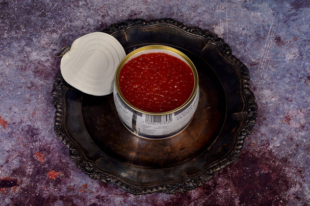 Nyissa ki a konzervdobozt vörös lazac kaviárral antik ezüst tányéron. Rusztikus háttér, felülnézet, másolás tér - Fotó, kép
