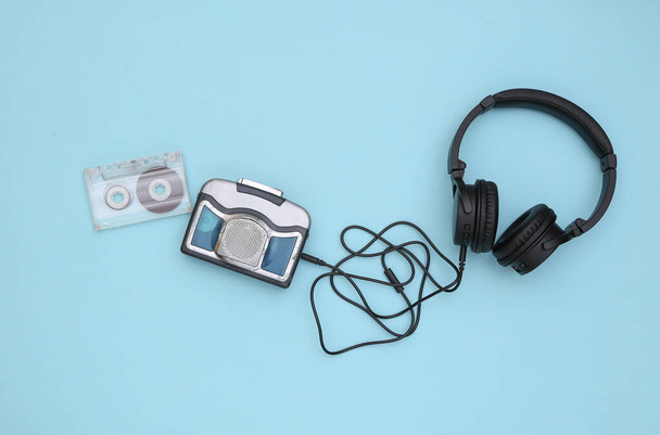 Μίνι συσκευή αναπαραγωγής ήχου με στερεοφωνικά ακουστικά σε μπλε φόντο. Άνω όψη - Φωτογραφία, εικόνα