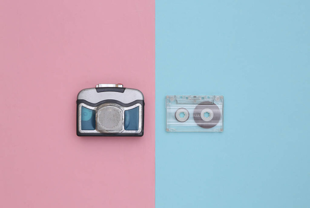 Mini audio cassette player with audio cassette on a blue pink background. Top view - Photo, Image