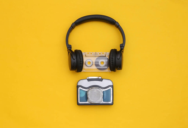 Μίνι συσκευή αναπαραγωγής ήχου με στερεοφωνικά ακουστικά σε κίτρινο φόντο. Άνω όψη - Φωτογραφία, εικόνα