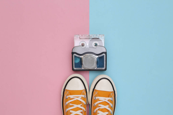 Retro sneakers and mini audio player on a blue pink background. Top view - Foto, Imagem