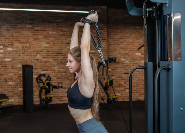 Sopii nainen täydellinen kehon koulutus triceps kaapeli käyttää konetta kuntosalilla - Valokuva, kuva
