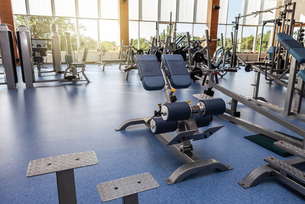 Interior da moderna sala de fitness ginásio com esportes e equipamentos de fitness contra as grandes janelas - Foto, Imagem