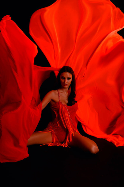 sexy brunette in a red suit on a dark background in the studio - Foto, immagini