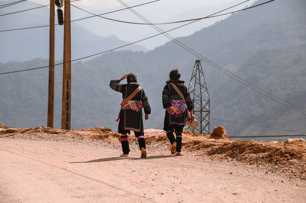 Женщины из племени хмонгов, одетые в традиционную одежду, возвращаясь в деревню Лао Цай в Сапа, Вьетнам - Фото, изображение