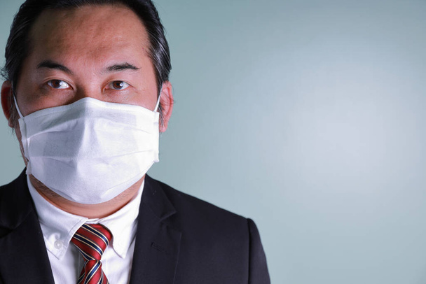 Close up retrato de empresário asiático vestindo uma máscara médica olhando para a câmera com espaço de cópia. Conceito empresários cuidados de saúde para proteger a gripe pandêmica coronavírus. Fotografia Interior no estúdio. - Foto, Imagem