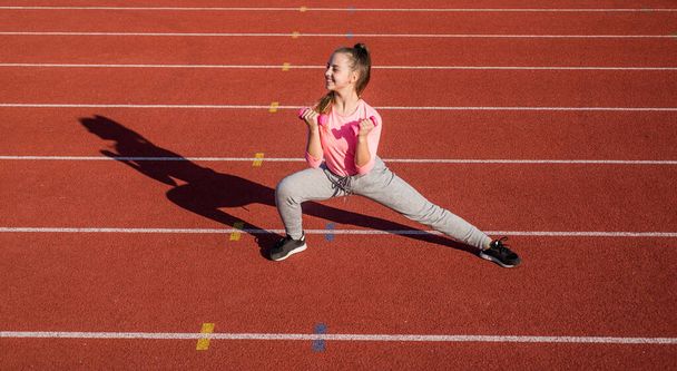 healthy child girl training dumbbells on stadium running track, power - Φωτογραφία, εικόνα