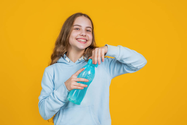 happy smiling child girl hold water bottle for drinking after sport workout, water balance - Foto, Imagen