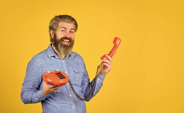 hello 80s. Man with moustache holding vintage phone. vintage communication device. Businessman talking on vintage phone in office. agile business. vintage stationary telephone. some unique creations - Фото, изображение