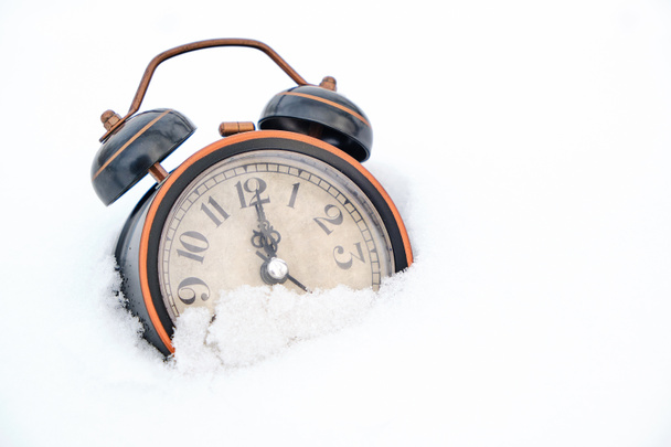 Old retro alarm clock in winter in snow on white background shows twelve hours - Fotoğraf, Görsel