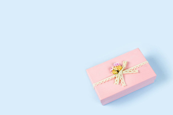 Розовая подарочная коробка на голубом фоне. Копирование пространства. - Фото, изображение