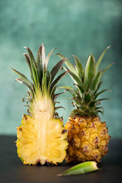 fresh cut mini pineapple on green background, close-up - Photo, image