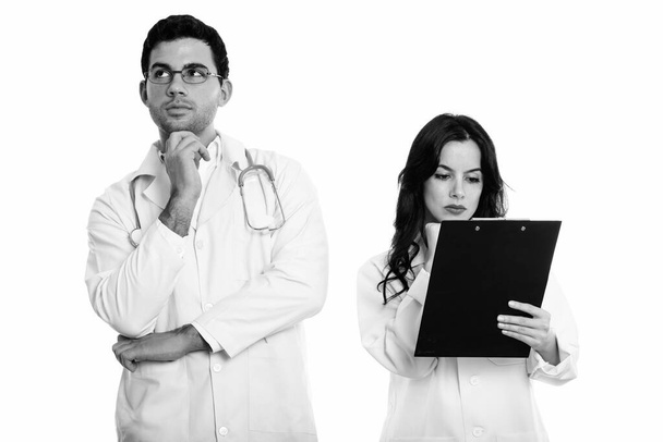 Studio di giovane uomo e donna medico pensare con donna medico leggere negli appunti - Foto, immagini