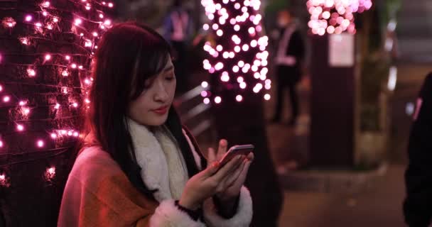 Japonská dívka volá telefon v noci osvětlené ulici v Shibuya close shot - Záběry, video