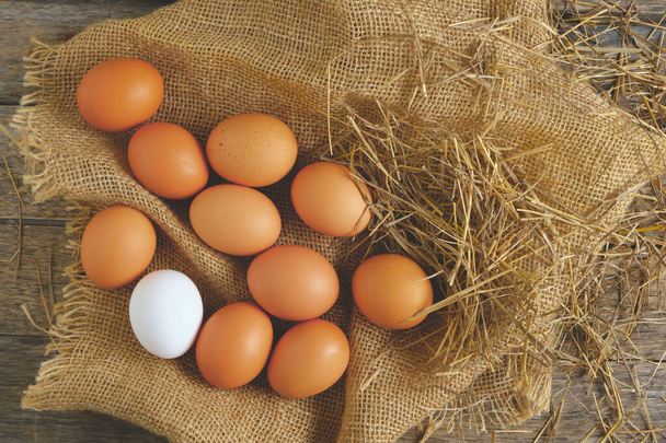 Chicken eggs on burlap in the chicken coop, top view - Foto, afbeelding