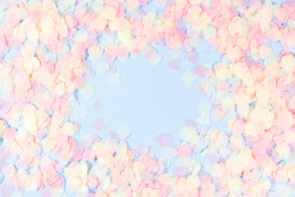 Holiday romantic gentle abstract background for the design. Pink confetti in shape of hearts on blue background. Top view, flat lay composition. Copy space for text. - Foto, Imagem