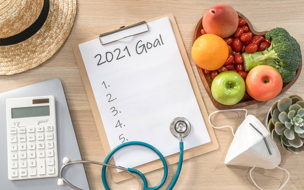 2021 Στόχοι νέου έτους στο νέο κανονικό τρόπο ζωής, ισορροπία μεταξύ εργασίας και ζωής με μάσκα προσώπου ευαισθητοποίηση για την ασφάλεια από covid-19, υγιεινά τρόφιμα, καλή υγεία της καρδιάς, κενή λίστα ανάλυσης σε λευκό χαρτί ιατρικό πρόχειρο - Φωτογραφία, εικόνα