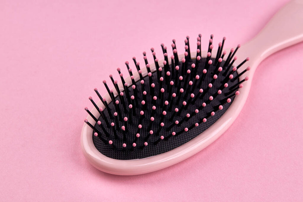 brosse à cheveux rose isolée sur un fond de corail rose avec espace. accessoire cheveux beauté pour coiffure - Photo, image