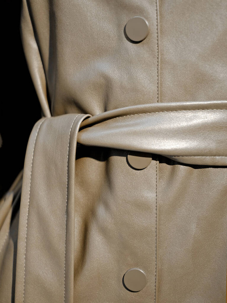 Female leather brown coat with belt close-up details in trends color, vertical photo. - Φωτογραφία, εικόνα