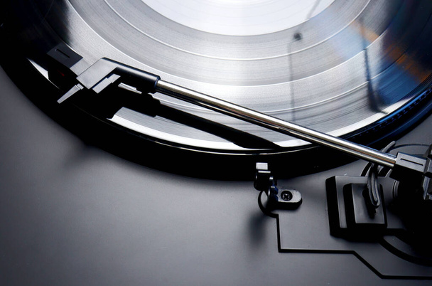 Black vinyl record spinning on a turntable - close up of a tonearm , lp and turn table - Photo, Image
