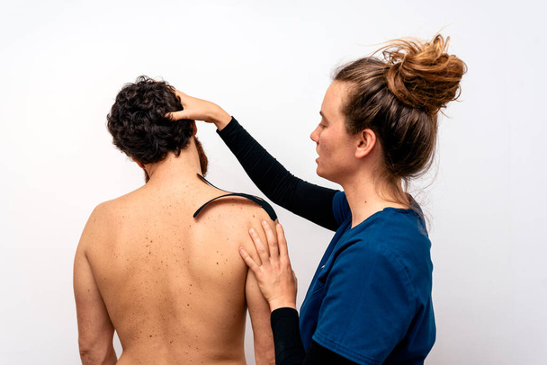 Stock photo of physiotherapist giving back massage to patient in clinic. - Valokuva, kuva