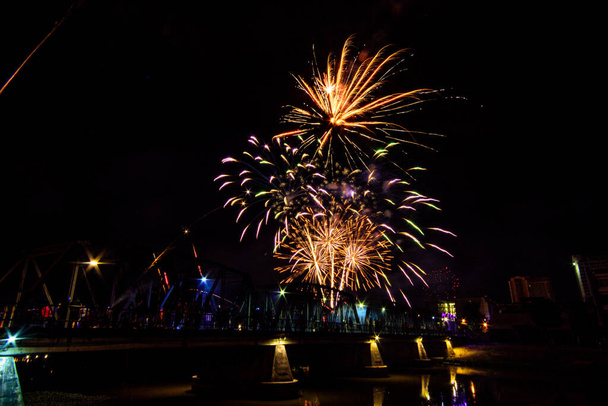 Coloridos fuegos artificiales muestran sobre puente de hierro que la celebración de la víspera de Año Nuevo en Chiang Mai, Tailandia. - Foto, imagen