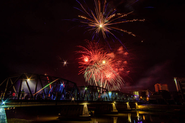 Kolorowy pokaz fajerwerków na żelaznym moście to święto na Sylwestra w Chiang Mai, Tajlandia. - Zdjęcie, obraz