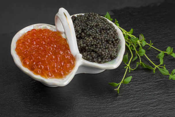 Caviar vermelho e preto fresco em bawl sobre fundo preto - Foto, Imagem