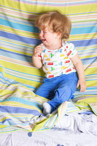 Little child is crying  on the bed - Photo, Image