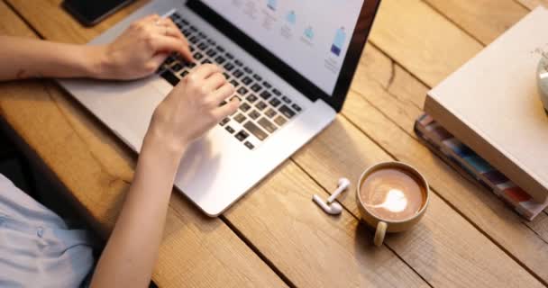 Mujer trabajando en el ordenador portátil con una taza de café - Metraje, vídeo