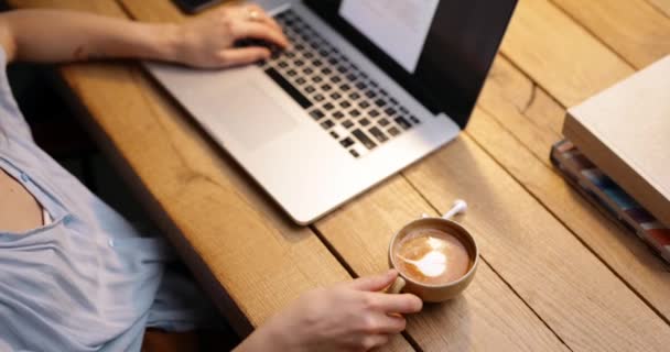 Frau arbeitet mit Kaffeetasse am Laptop - Filmmaterial, Video