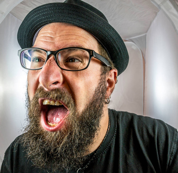 Бородатый, кричащий и злой мужчина в черных очках - Фото, изображение