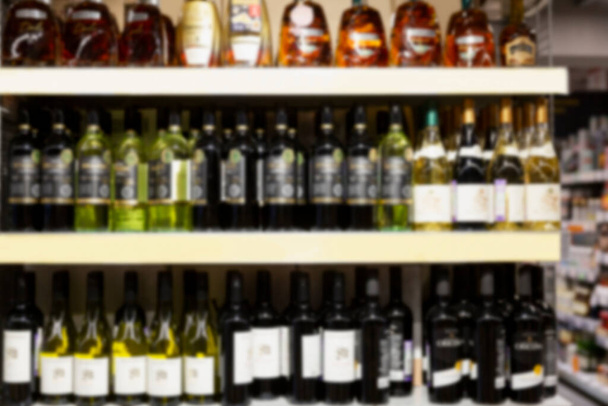 Alcohol bottles on the shelves in the store. Front view. Blurred. - Foto, imagen