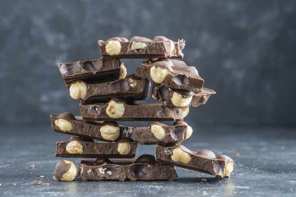 Pile chocolate with nuts on the gray background, close up - Фото, зображення