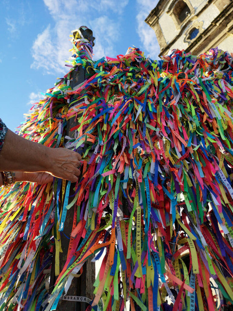 Manos femeninas atando cintas de colores en la rejilla de la iglesia Bonfim en Salvador Bahia Brasil. - Foto, Imagen