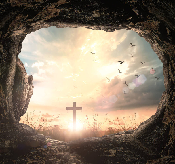 Koncepcja Wielki Piątek: Pusty kamień grobowy z krzyżem na tle wschodu słońca łąki - Zdjęcie, obraz