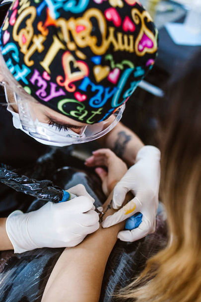 mestre de tatuagem de mulher latina mostrando um processo de criação de tatuagem na cidade do México - Foto, Imagem