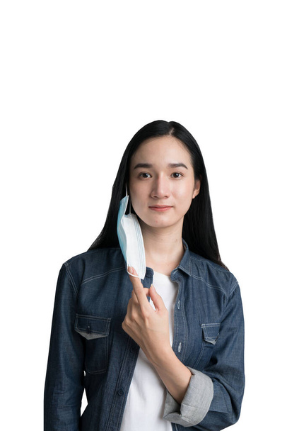 A beautiful woman removing a mask for virus protection with clipping path - Φωτογραφία, εικόνα